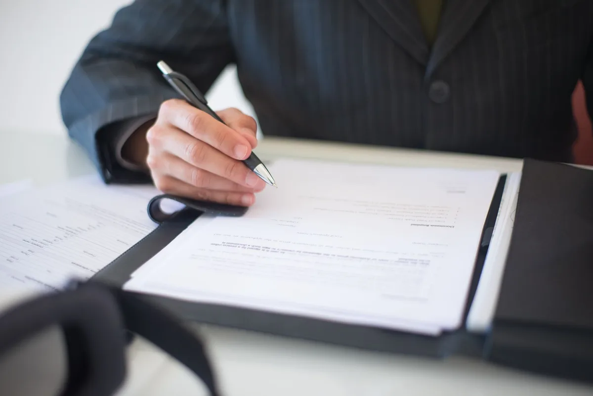 Executivo assina documento empresarial em pasta